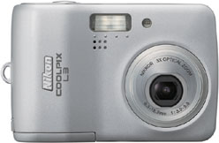 Máquina digital Nikon Coolpix L3 - Frente - Cortesia da Canon, editada pelo Câmera versus Câmera